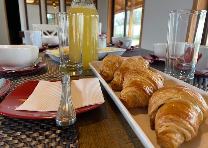 Desayuno servido en Casa Parral con croissants y jugo natural